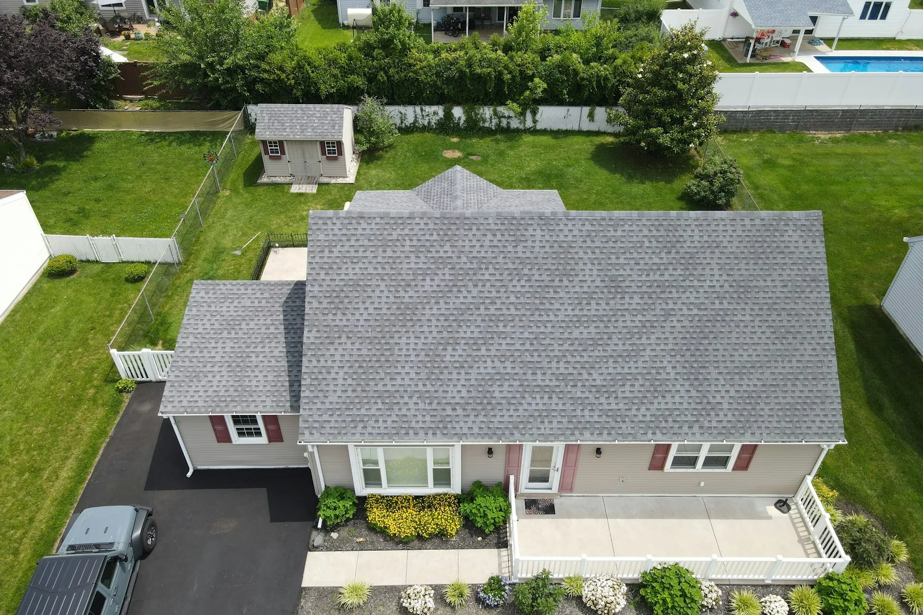 Aerial view of a suburban house with a newly shingled gray roof